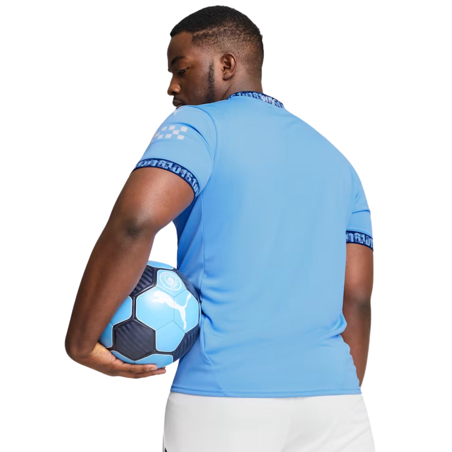 Man holding a blue soccer ball wearing a light blue soccer jersey with brand logos.
