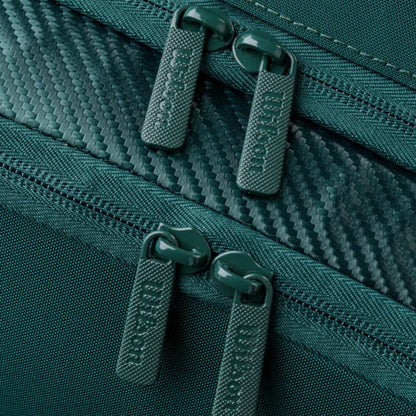 Close-up of green zippers on a textured fabric surface
