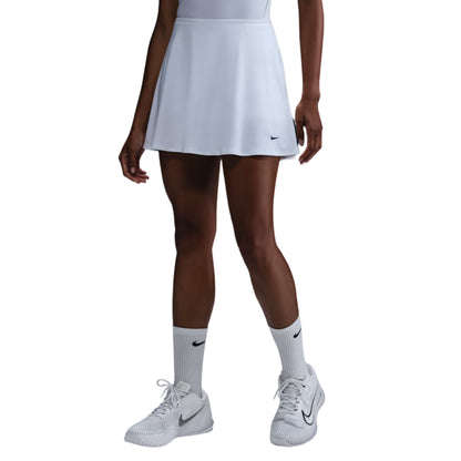 Person wearing a white Nike tennis skirt, socks, and shoes on a white background