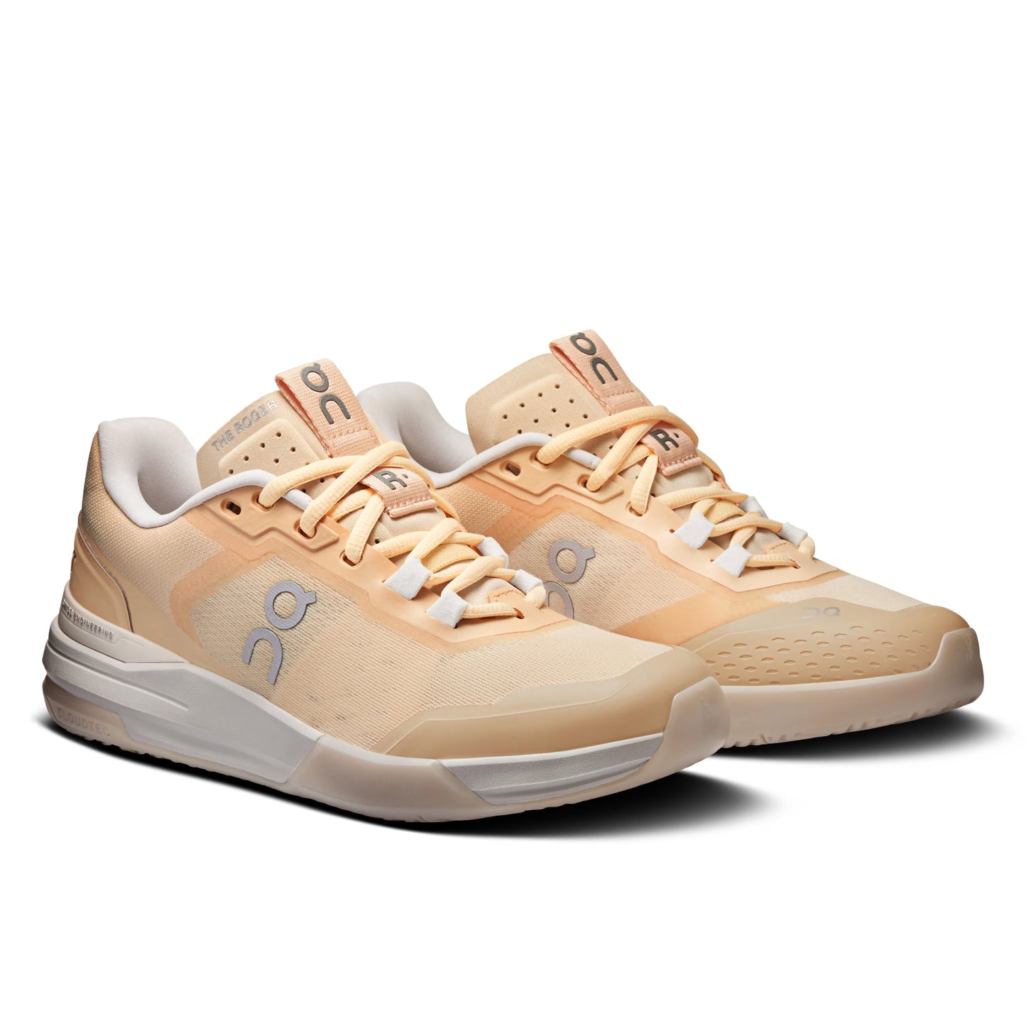 A pair of On running shoes in a warm peach and beige colorway, featuring the brand's signature 'on' logo on the side and tongue, set against a clean white background.