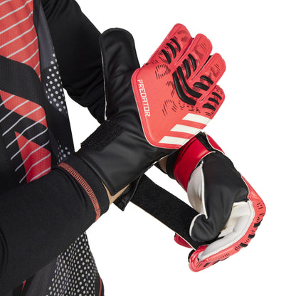 Red and black Adidas soccer gloves with 'Predator' branding on a white background