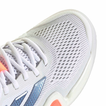 Close-up of a white tennis shoe with orange accents on a white background