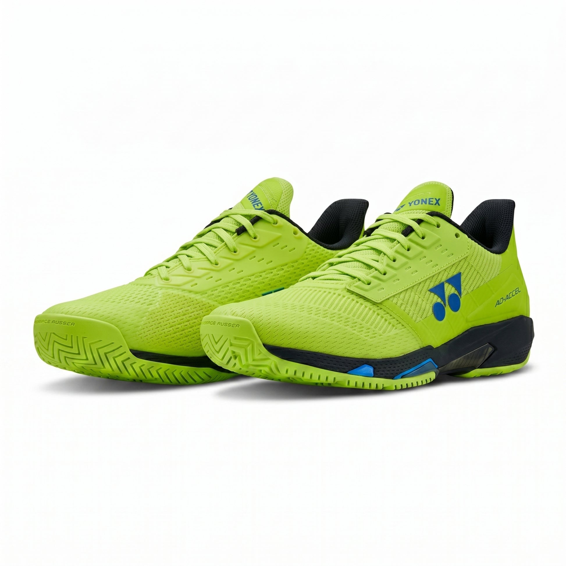 Pair of bright green Yonex shoes with black soles on a white background