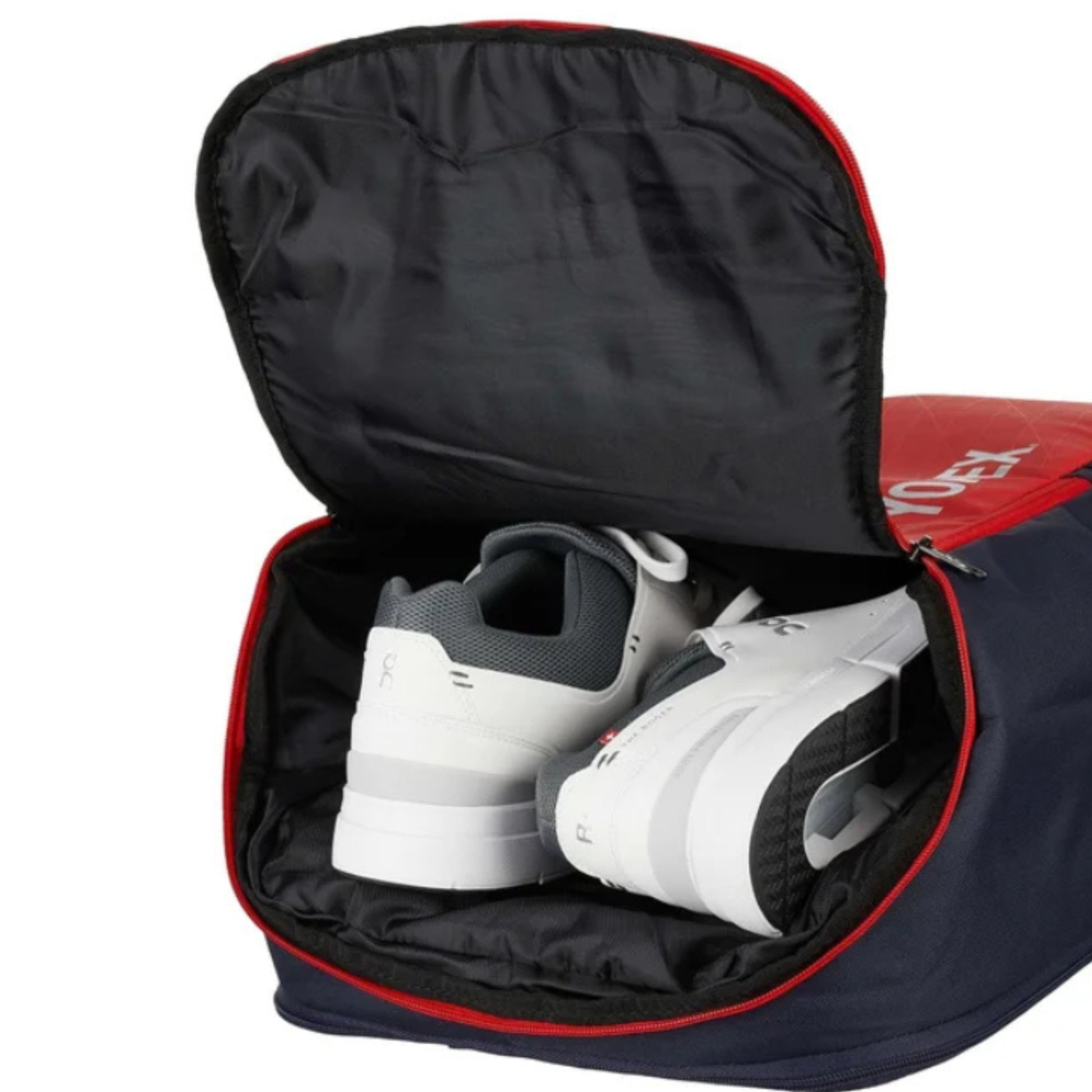Navy and red Yonex backpack with white sneakers inside on a white background
