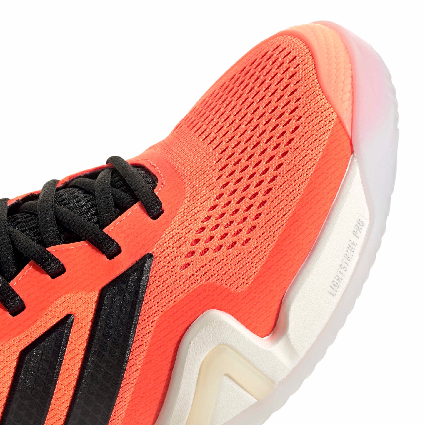 Close-up of a orange and black tennis shoe with a white sole on a white background