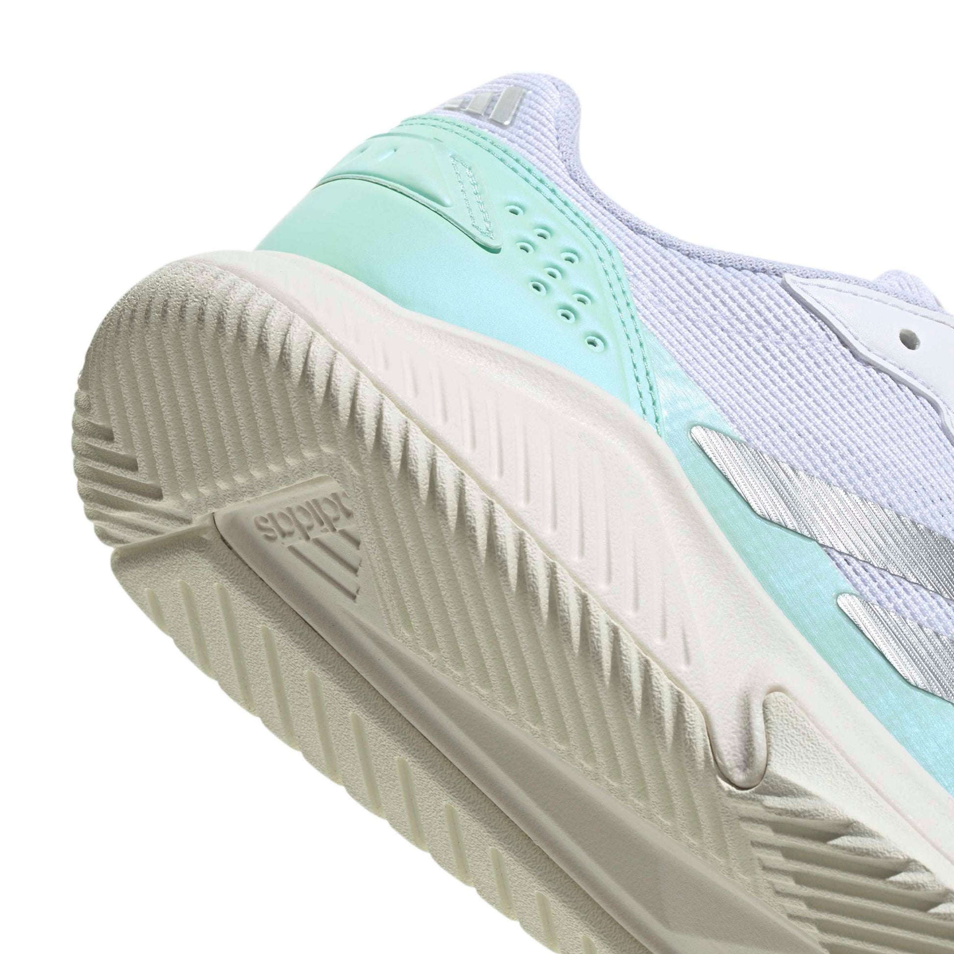 Close-up of the heel and midsole of a running shoe in mint green, white, and light lavender, showing the textured outsole and side branding details.