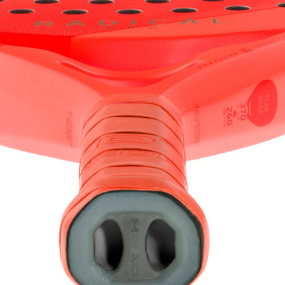 Close-up of a red Head padel racket with 'Radical' branding on a white background