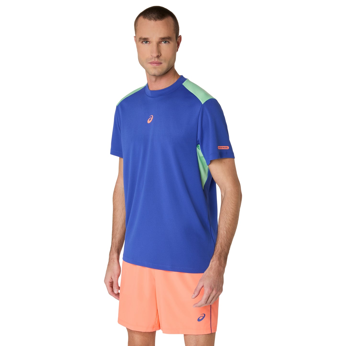 Man wearing a blue and green athletic shirt with orange shorts on a white background