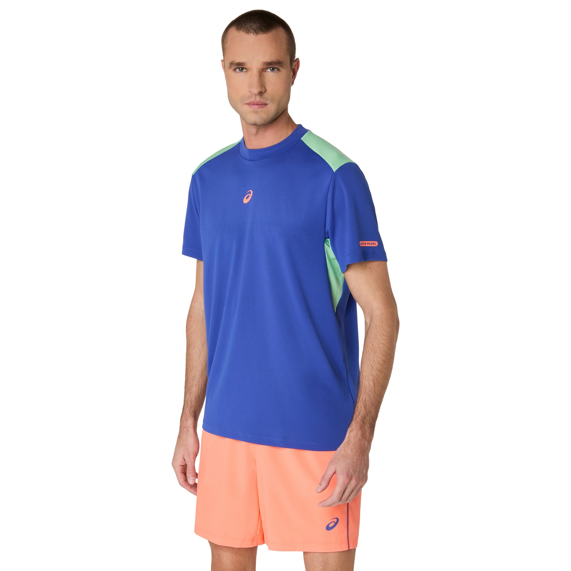 Man wearing a blue and green athletic shirt with orange shorts on a white background