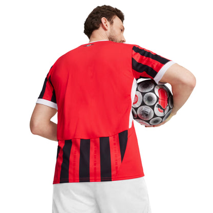 Person wearing a red and black striped soccer jersey holding a soccer ball.