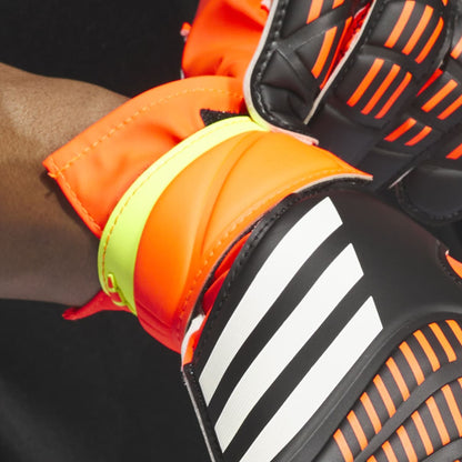 Close-up of orange and black sports gloves with a brand logo.