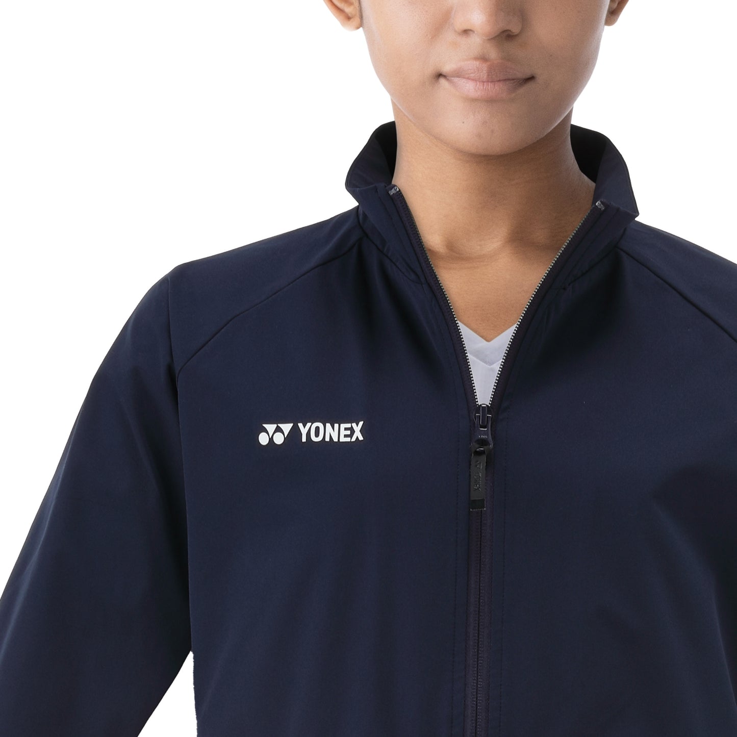 Person wearing a navy blue jacket with Yonex logo on a white background