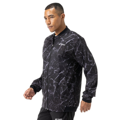 Man wearing a black and gray patterned Yonex jacket on a white background