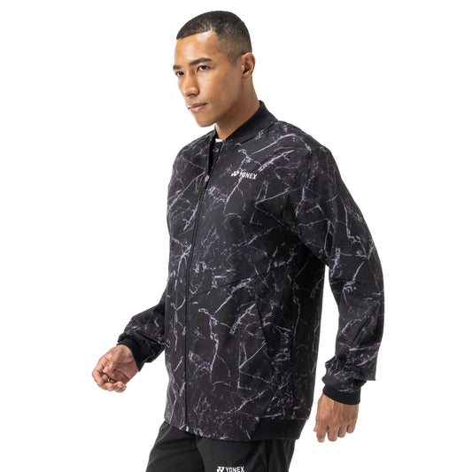 Man wearing a black and gray patterned Yonex jacket on a white background