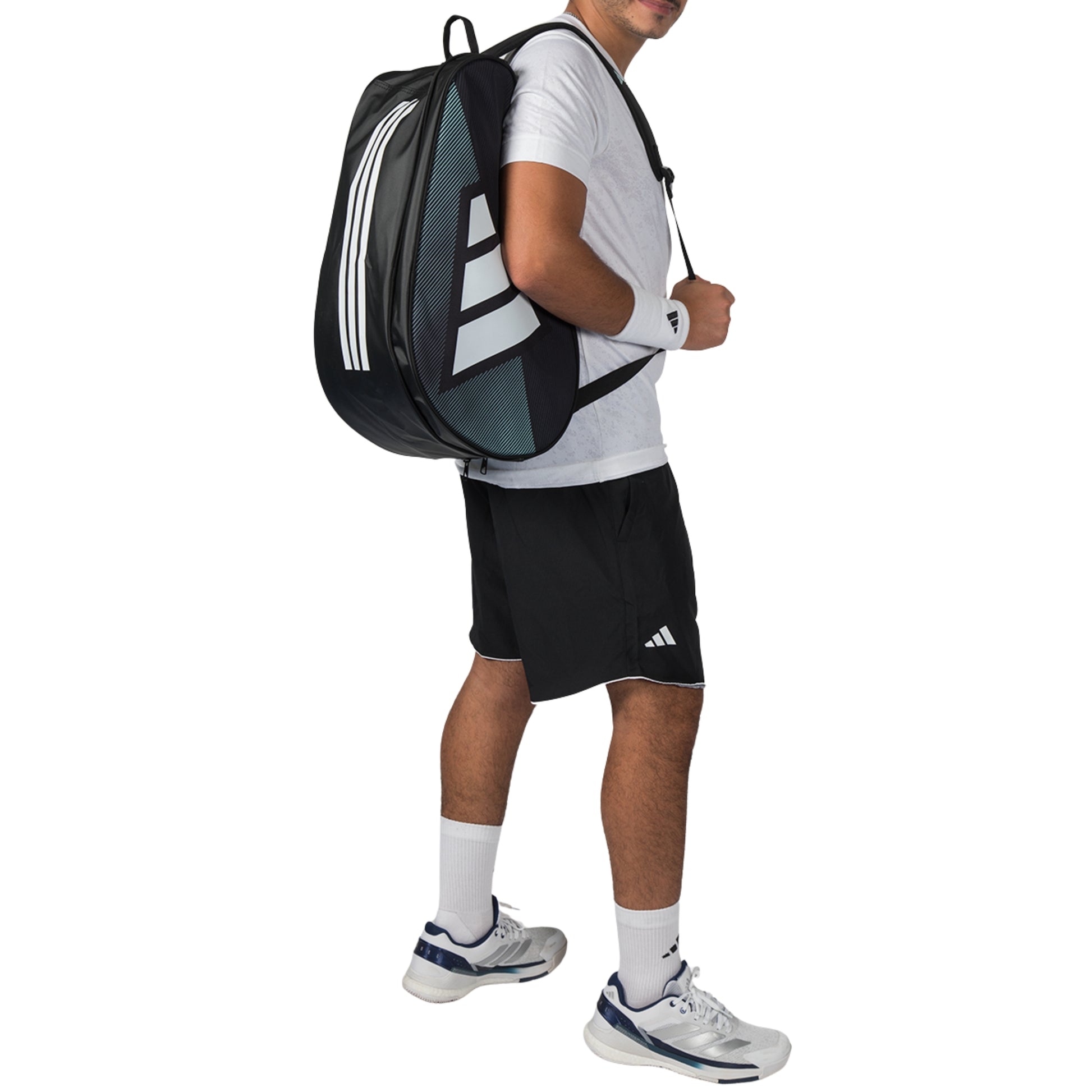 Person wearing a black Adidas racket bag and athletic outfit on a white background