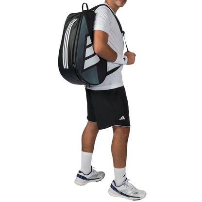 Person wearing a black Adidas racket bag and athletic outfit on a white background