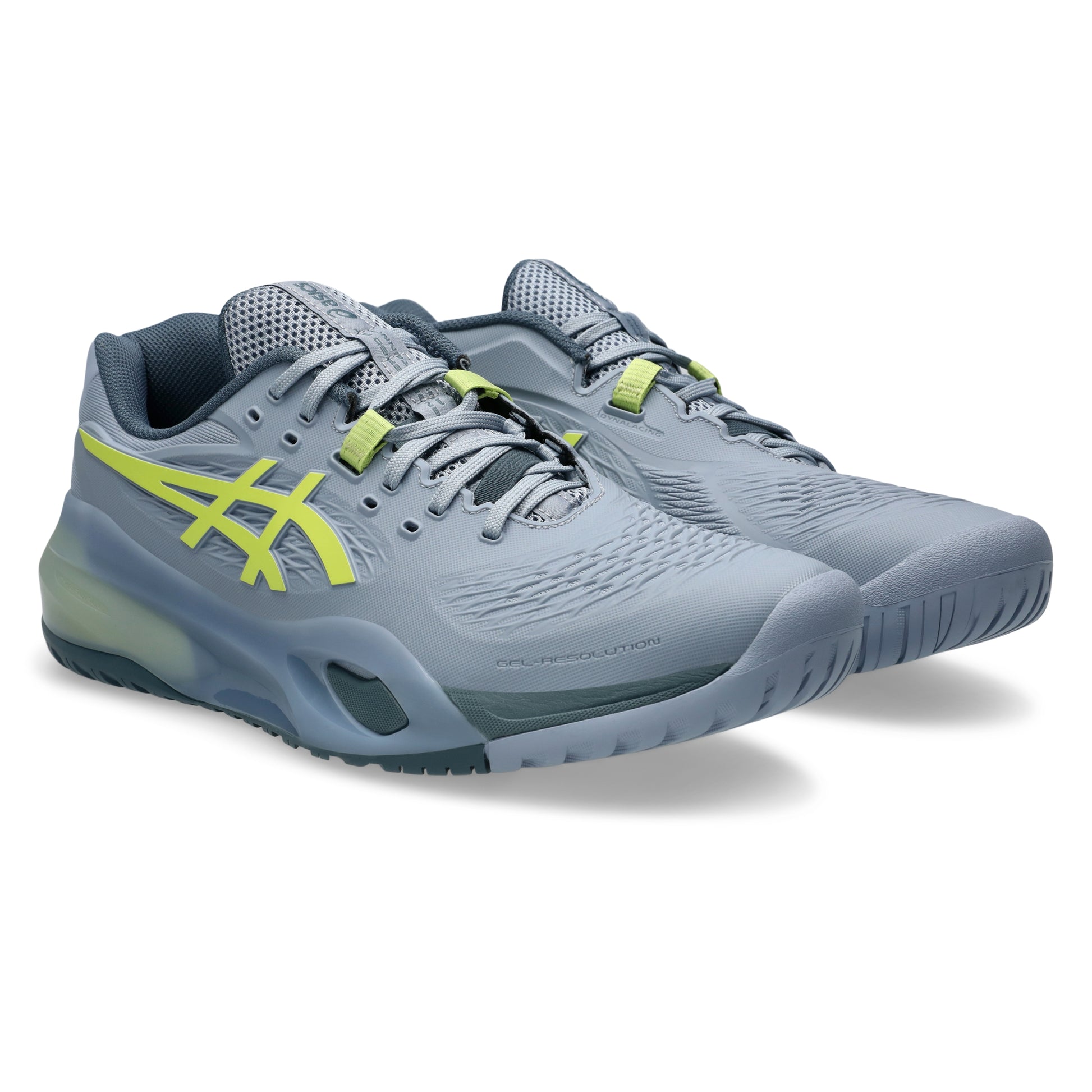 Gray tennis shoes with green accents on a white background