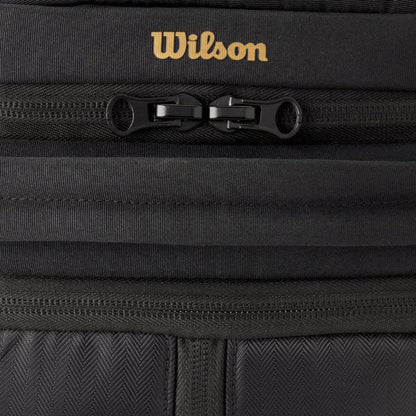Close-up of a black bag with a gold Wilson logo on a black background