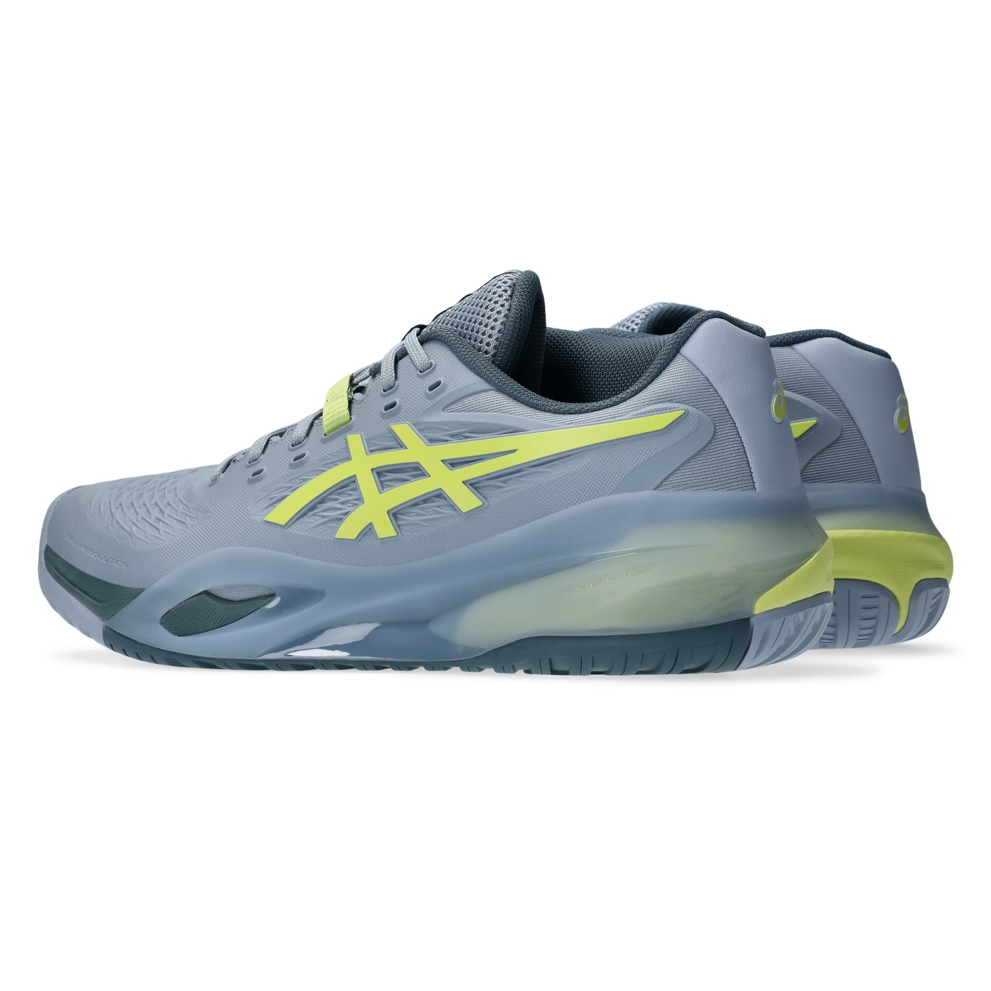 Gray tennis shoes with green accents on a white background