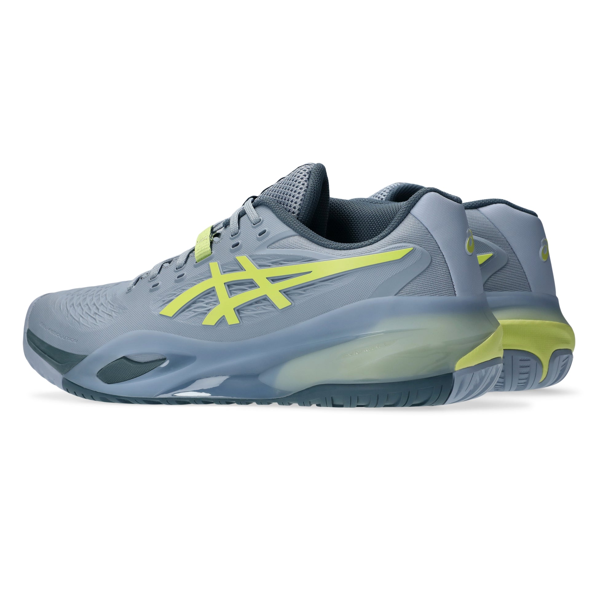 Gray tennis shoes with green accents on a white background