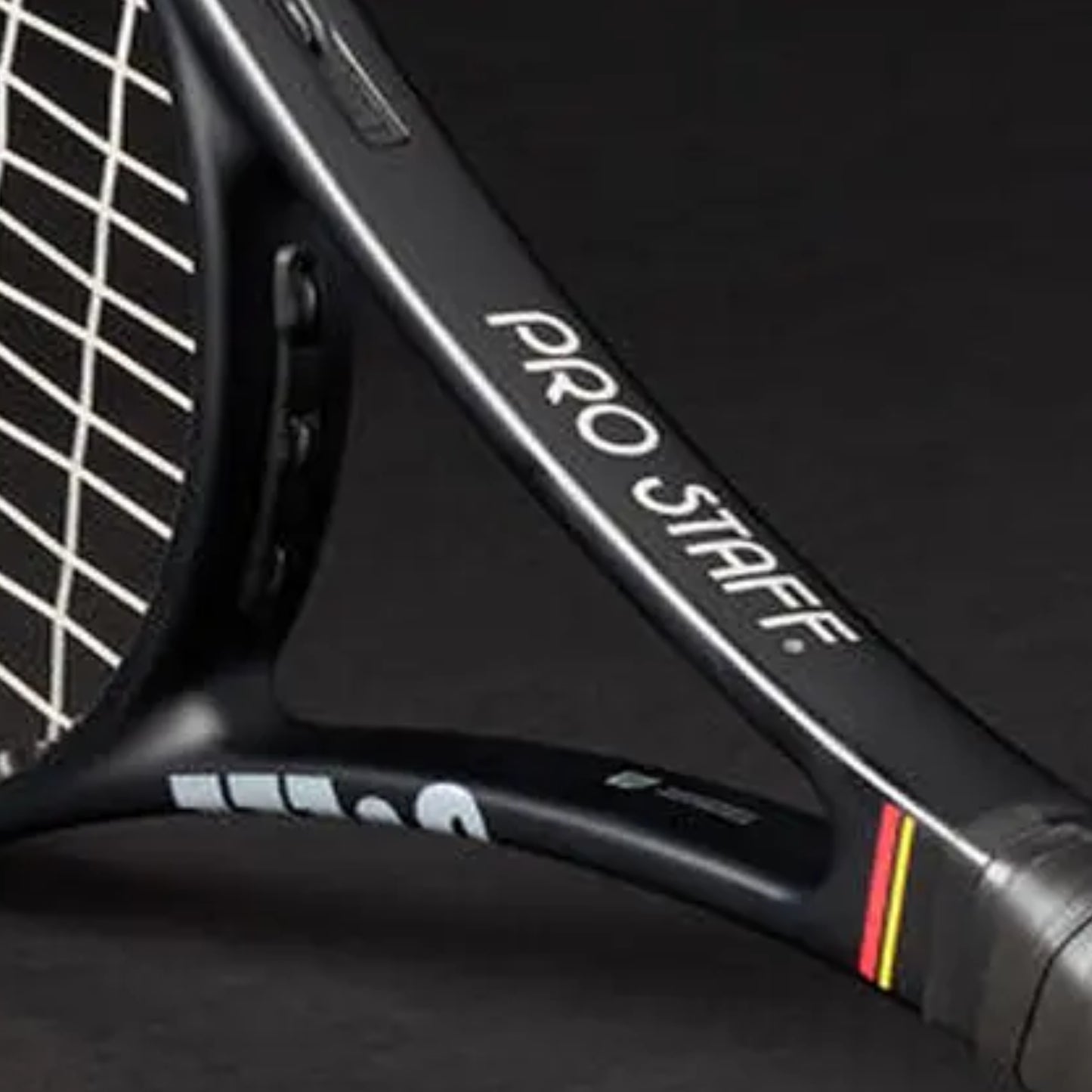 Close-up of a tennis racket with 'Pro Staff' branding on a dark background
