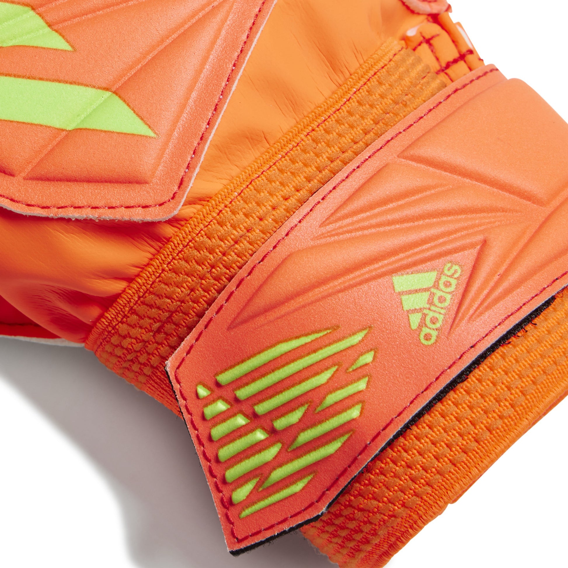 Close-up of orange sports gloves with green accents and Adidas logo on a white background