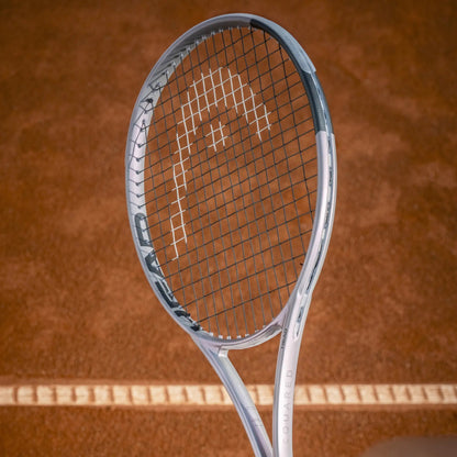 Silver Head tennis racket on a brown tennis court