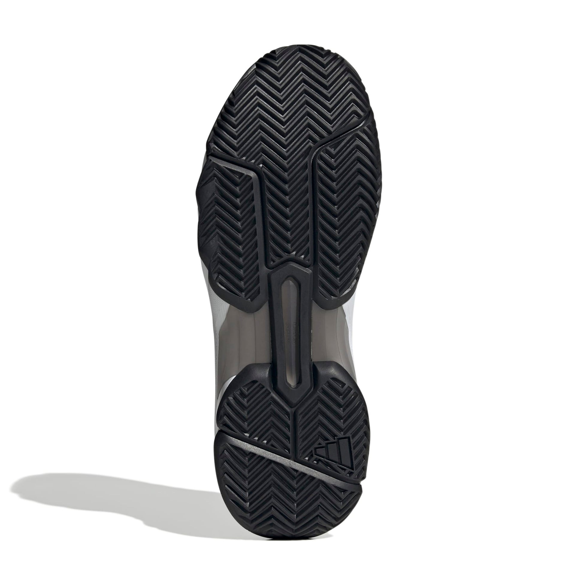 The outsole of a tennis shoe, showing a black herringbone tread pattern with a translucent gray midsole section, photographed on a white background with a soft shadow.