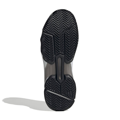 The outsole of a tennis shoe, showing a black herringbone tread pattern with a translucent gray midsole section, photographed on a white background with a soft shadow.
