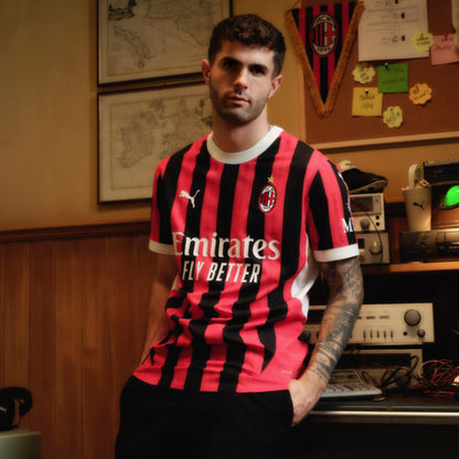 Person wearing a red and black Puma striped sports jersey with visible branding in an indoor setting.
