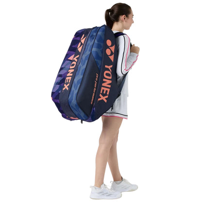 Person carrying a Yonex tennis bag on a white background