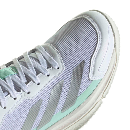 Close-up of a white and mint green athletic shoe showing the side panel, laces, and textured mesh upper.