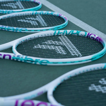 Close-up of tennis rackets with a brand logo on a green court surface