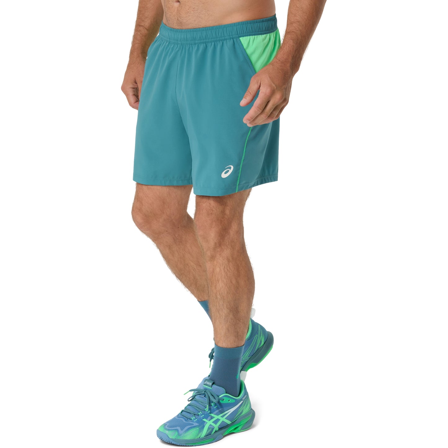Person wearing teal shorts with a white background