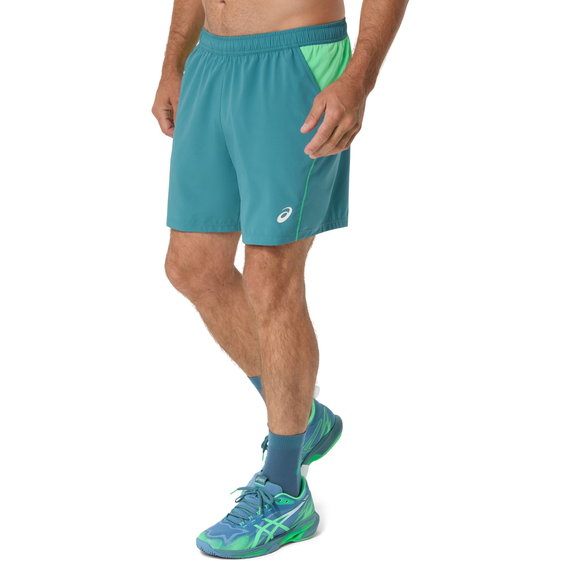 Person wearing teal shorts with a white background
