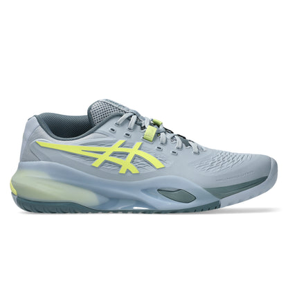 Gray tennis shoe with yellow accents on a white background