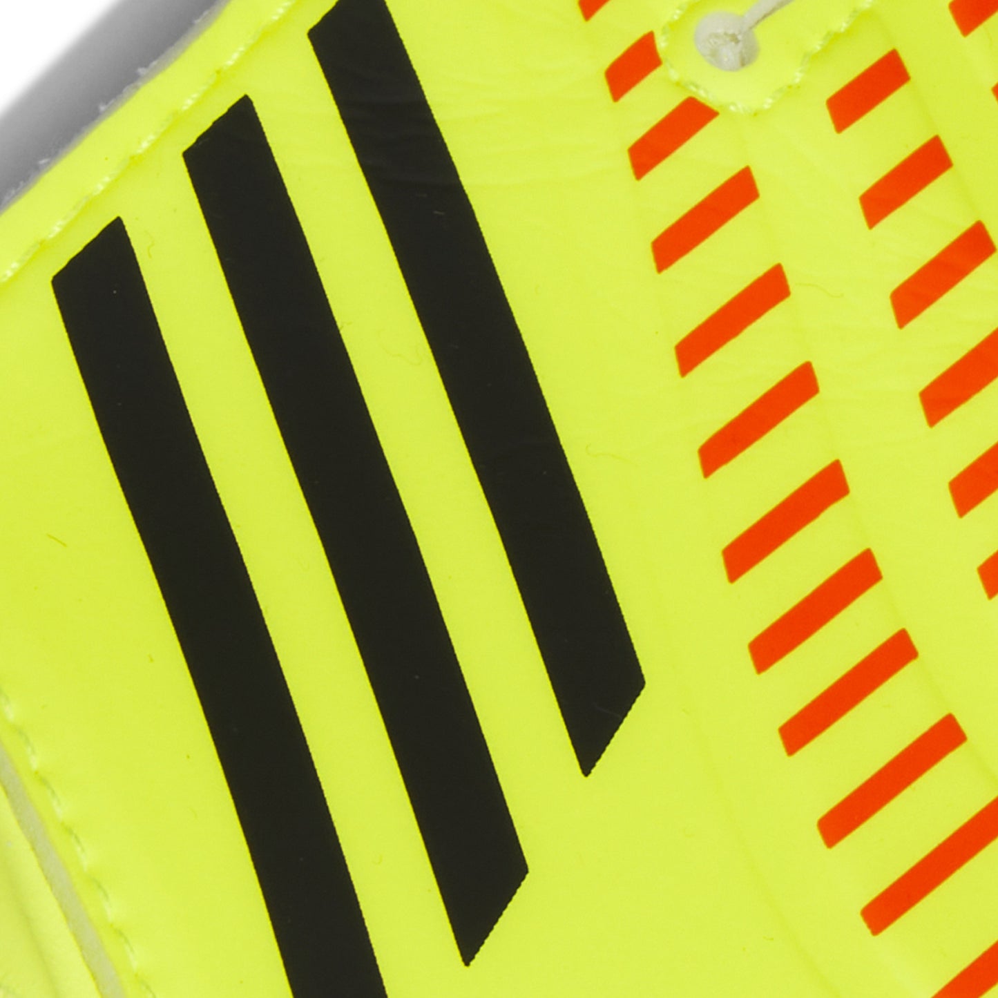 Close-up of a sports shoe with black stripes and red warning stripes on a yellow background