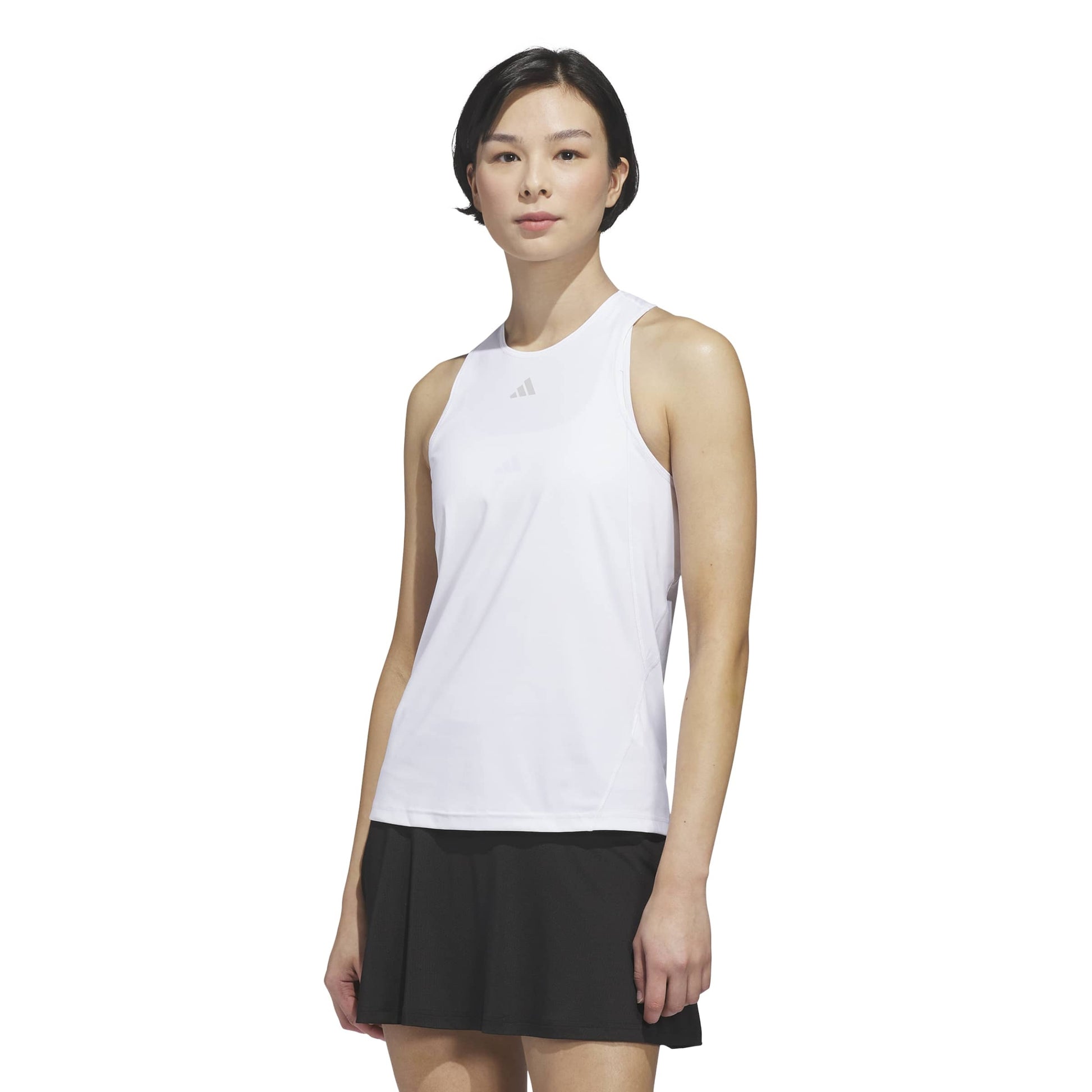Woman wearing a white sleeveless adidas top with a logo on a white background