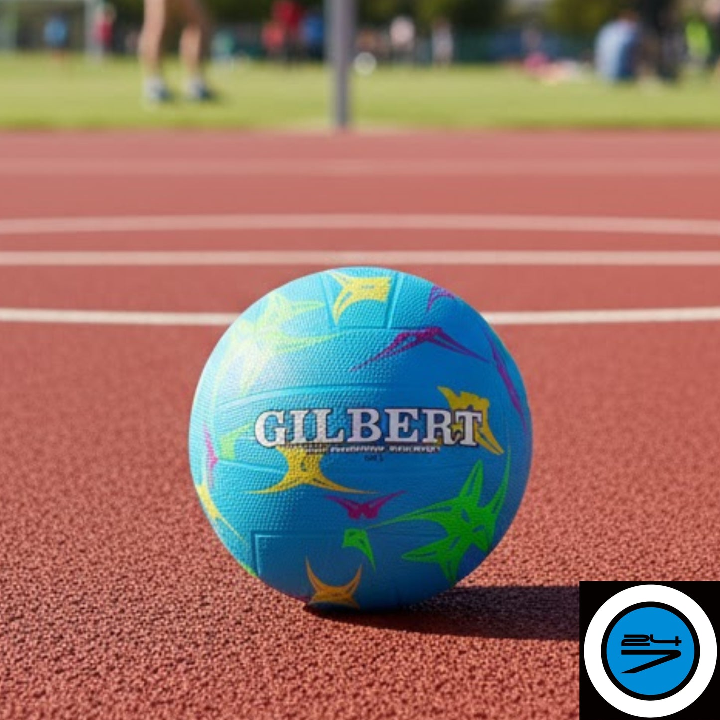 Gilbert blue netball ball with colorful designs on a netball court, featuring the Gilbert brand.