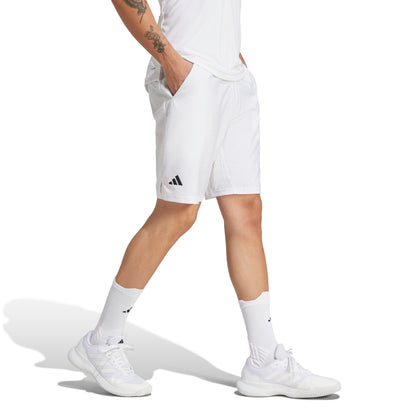 Person wearing white Adidas shorts and shoes on a white background