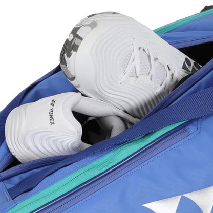 White sports shoes with black and gray accents peeking out from a blue tennis bag.