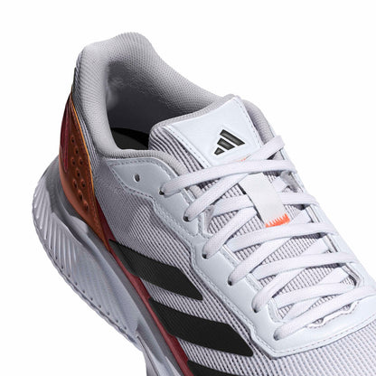 White padel shoe with black stripes and orange accents on a white background
