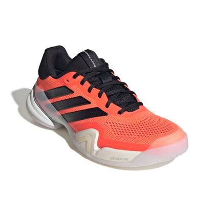 Orange Adidas tennis shoe with black stripes on a white background