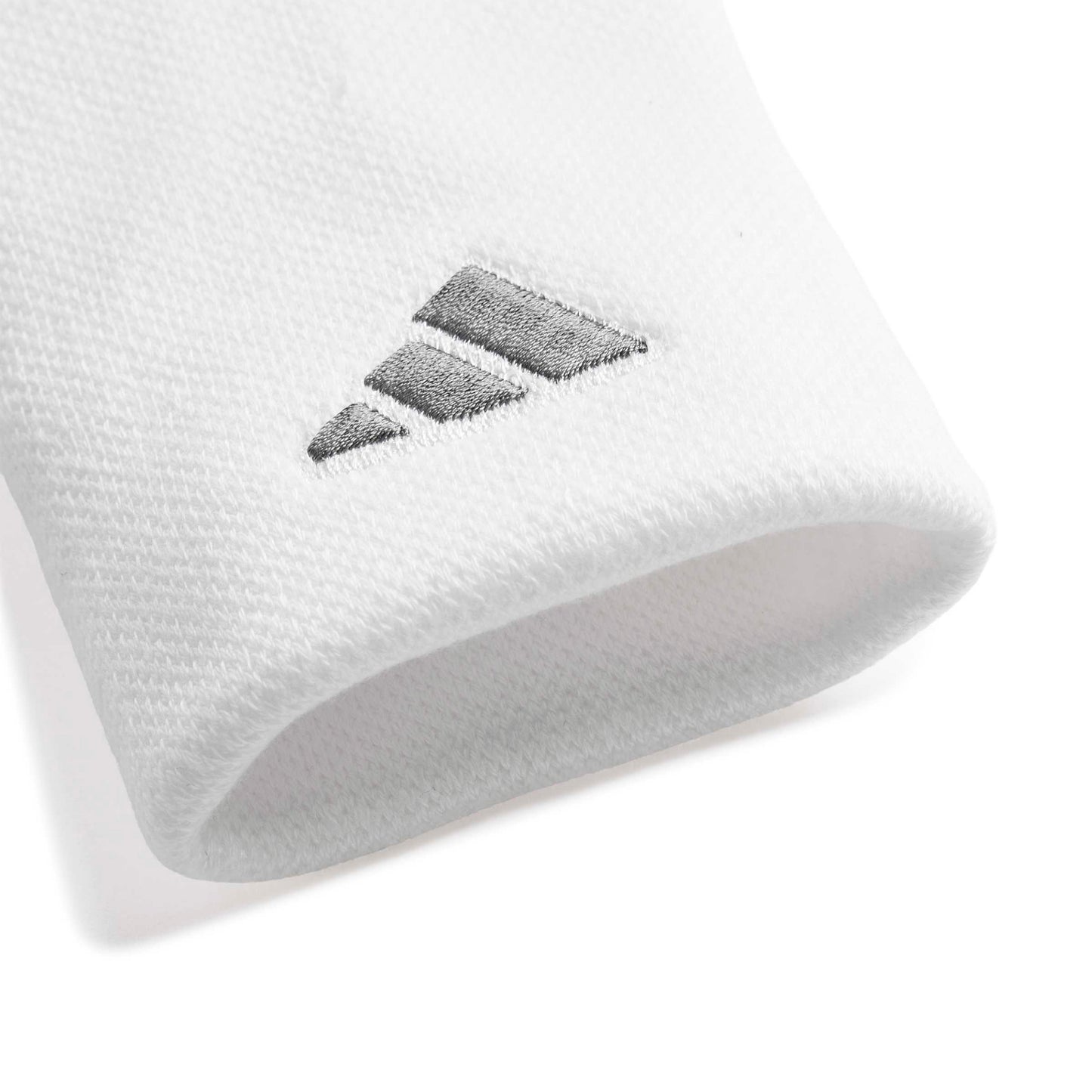 A close-up of a white wristband accessory featuring a dark gray embroidered Adidas logo.