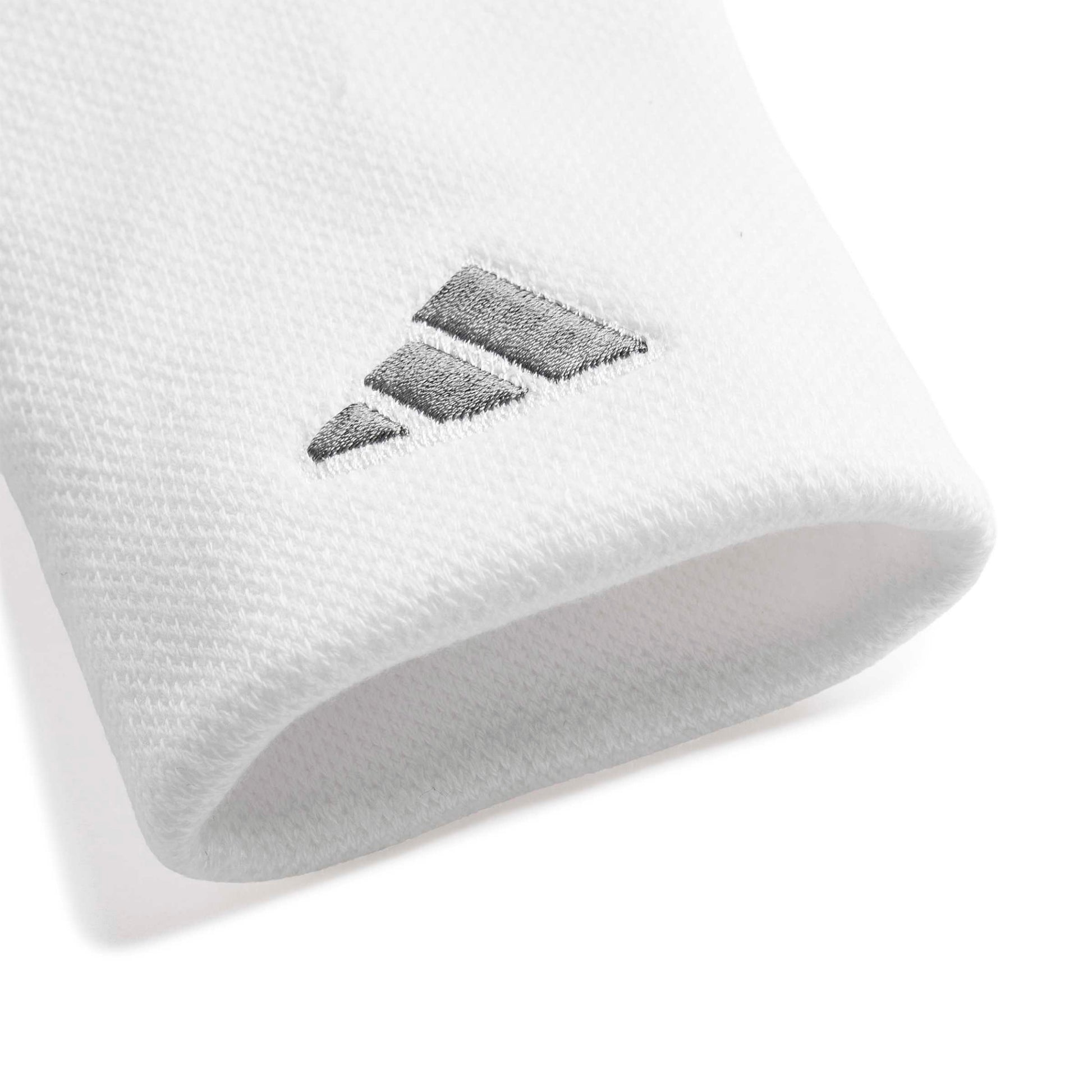 A close-up of a white wristband accessory featuring a dark gray embroidered Adidas logo.