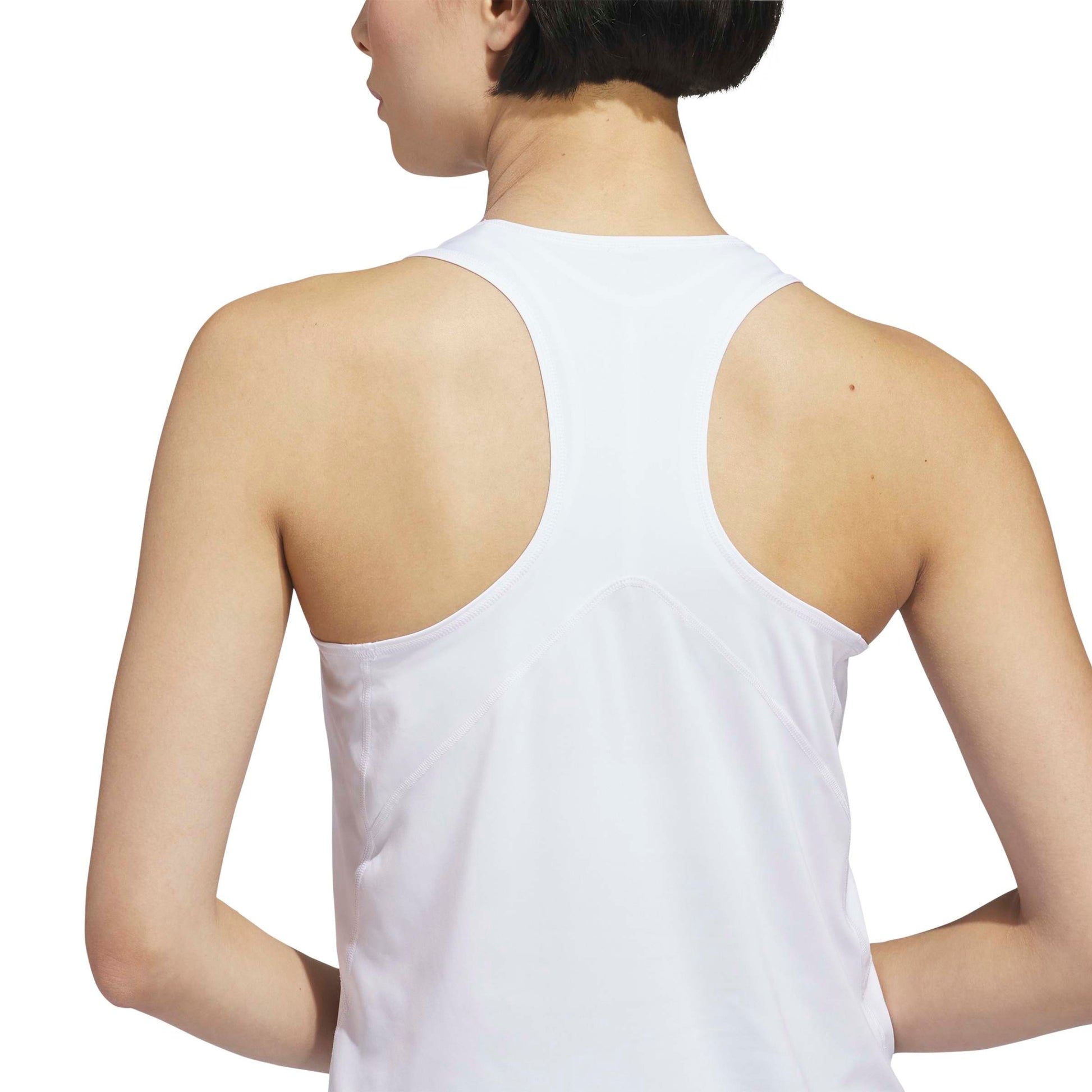 Person wearing a white Adidas tank top on a white background