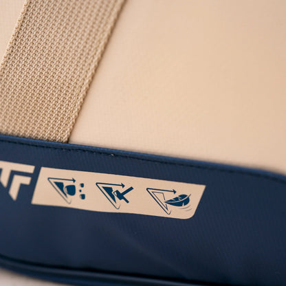 Close-up of a bag with a brand logo and symbols on a beige and blue background