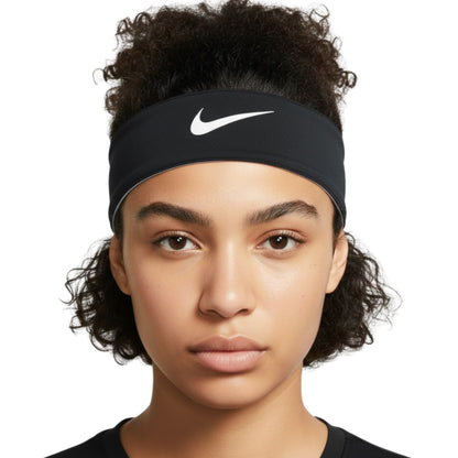 Person wearing a black Nike headband with a white logo on a white background