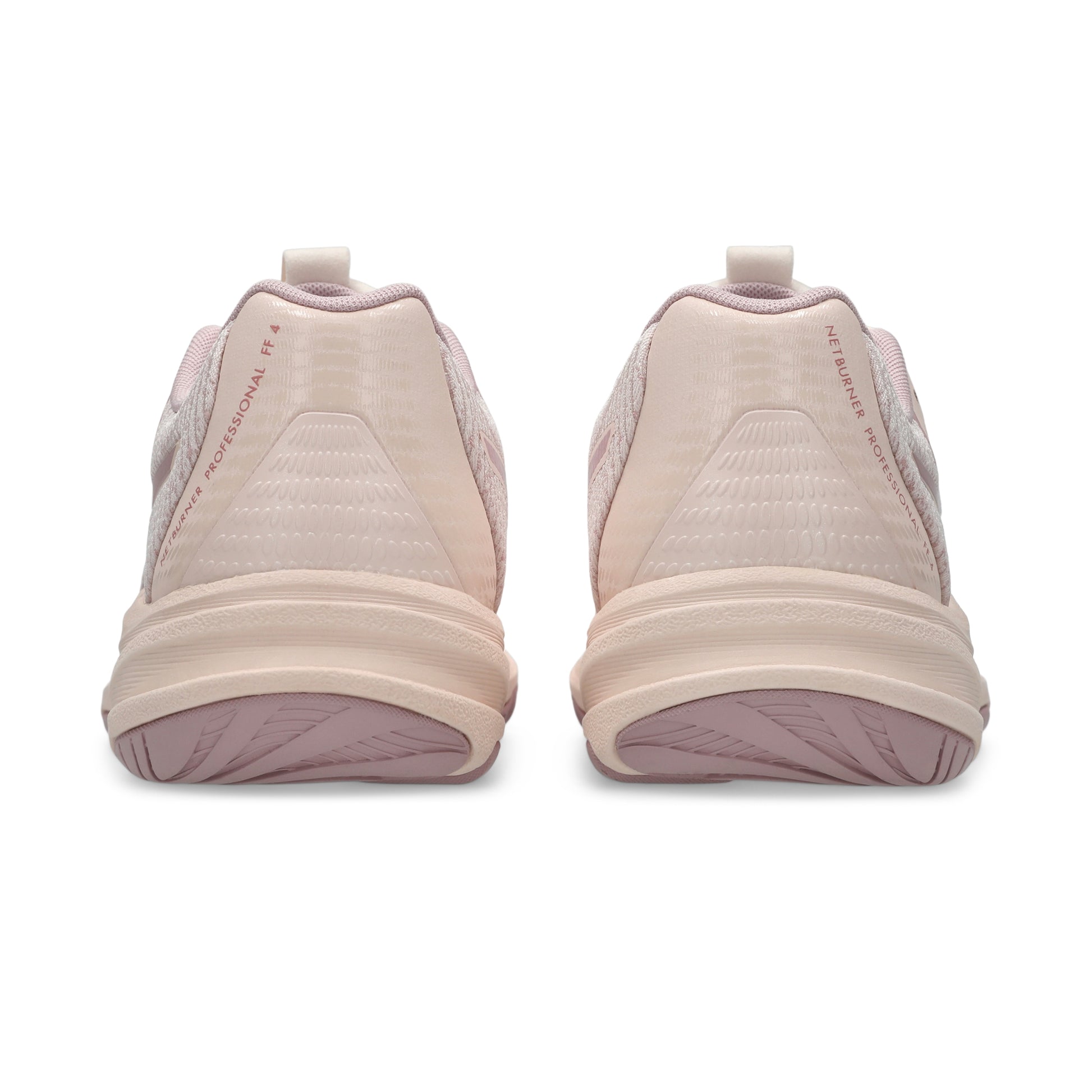 Pair of beige netball shoes with pink soles on a white background