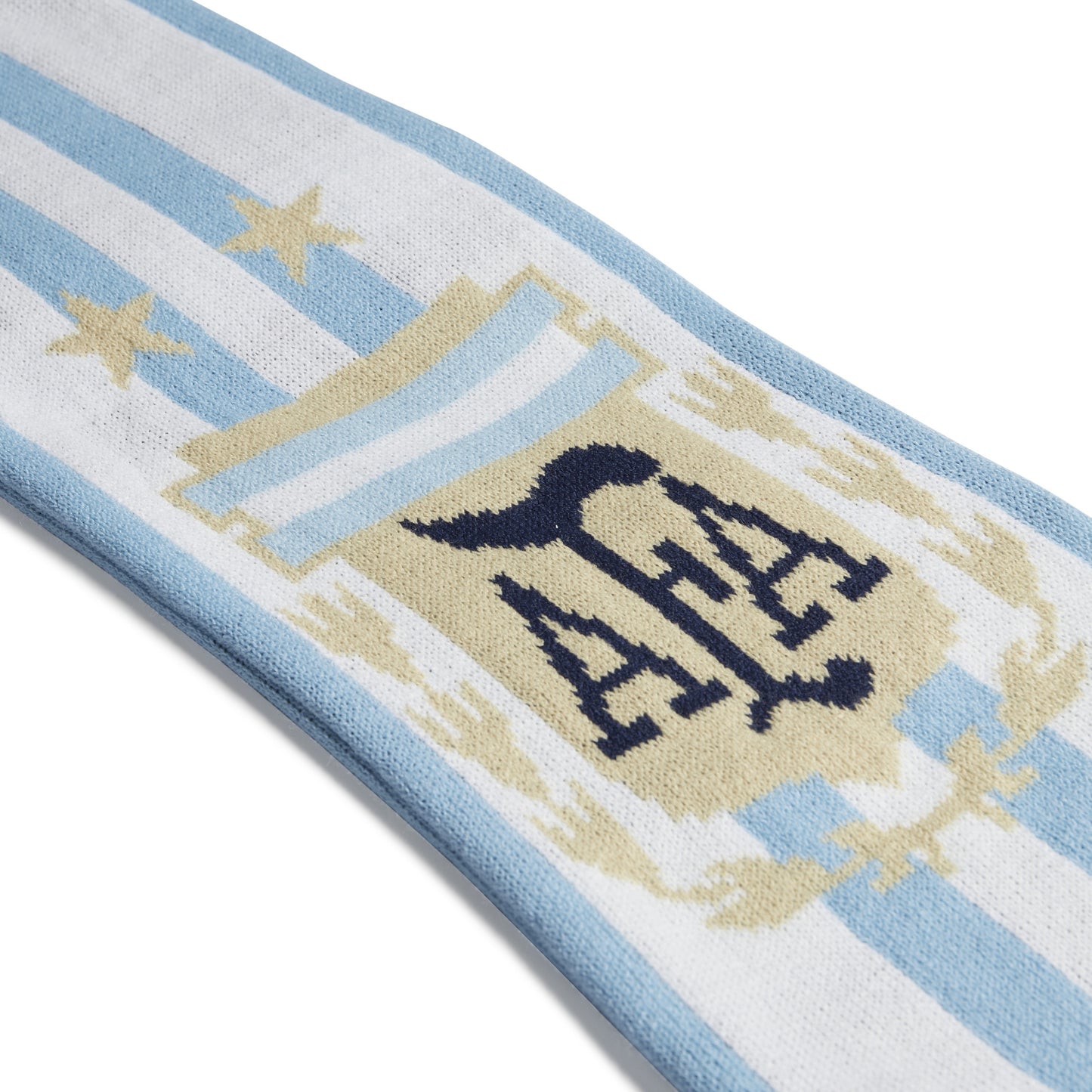 Close-up of a scarf with a crest and 'ALA' monogram on a white background